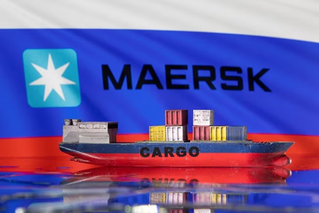 A cargo ship boat model is pictured in front of the Maersk logo and a Russian flag in this illustration taken March 3, 2022. REUTERS